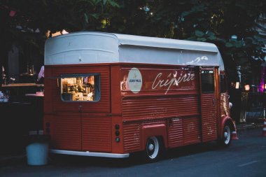 Akşam yemeği hazırlayan büyük kırmızı bir araba yolda duruyor.