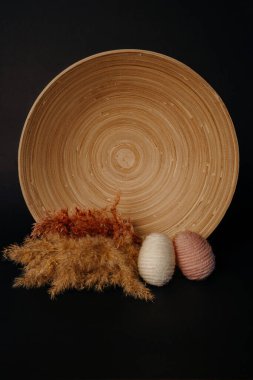 Paskalya dekoru. Bambu tabağında örülmüş yumurta ve pampa.