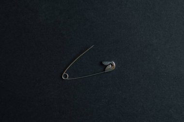 Siyah arkaplanda tek bir izole güvenlik iğnesi