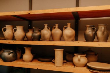many clay pots on shelves in a pottery. High quality photo
