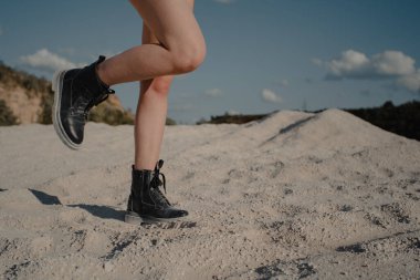 girl walking on sand. boots and legs. High quality photo