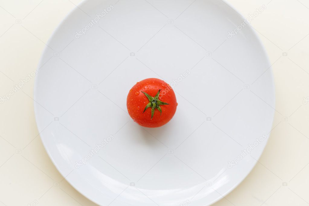 Ripe tomato on a white plate