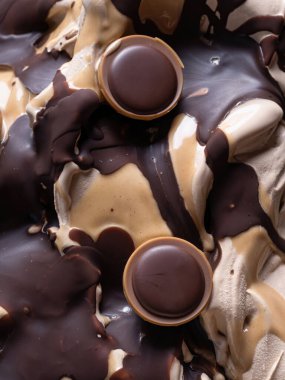 Dondurulmuş şekerleme aromalı dondurma - tüm çerçeve ayrıntıları. Karamel ve çikolata kaplı bej kremalı dondurmanın yüzey dokusunu kapatın..