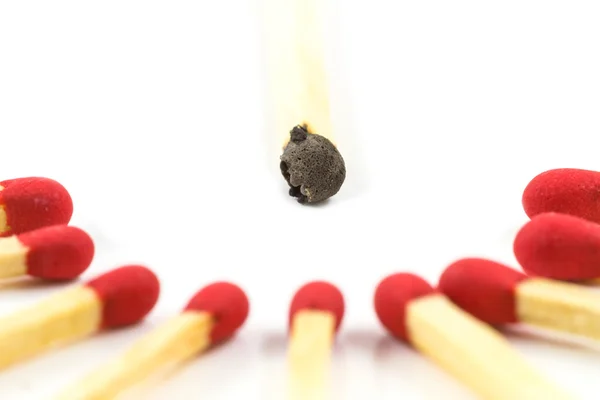 Palillo de cerillas rojo alrededor del palo de cerillas quemado aislado — Foto de Stock