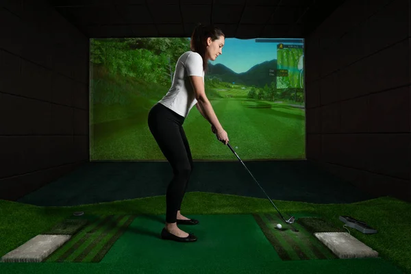 Ekran golfü oynayan bir kız. Golf Simülatörü. — Stok fotoğraf