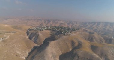 Yahudi yerleşimi İsrail 'deki Judea ve Samarya çöllerinde. Tepedeki evlerin, tepedeki dağ manzarasının hava görüntüsü. Açık Akdeniz 'de birlikte yaşamak