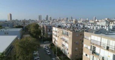 Beton evler ve çatıların üstündeki hava manzarası ve birçok güneş ısıtmalı su tankı, yeşil enerjiyi duş için kaynar su olarak kullanıyor. Şehir görüşü geleneksel yeşil enerji kavramı. 