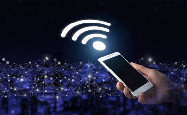 Şehirdeki iş ağı bağlantı konsepti ve Wi-Fi. Şehrin karanlık arka planında dijital hologram Wi-Fi yazısıyla el ele tutuşan beyaz akıllı telefon. Wi-Fi kablosuz kavramı