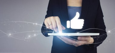 Tebrik ederim, iyi ve konsept gibi. Beyaz tablet, iş kadını elinde dijital hologram el feneri ile gri arka planda simge işareti oluşturur. Tumb konsepti