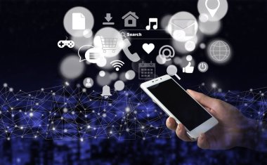 Sosyal medya ve dijital online konsept. Karanlık şehrin arka planında dijital hologram sosyal medya simgeleriyle el ele tutuşan beyaz akıllı telefon. Sosyal medya konsepti. İletişim ağı