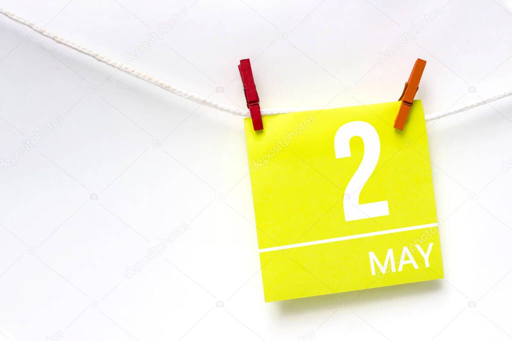 May 2nd. Day 2 of month, Calendar date. Paper cards with calendar day hanging rope with clothespins on white background. Spring month, day of the year concept