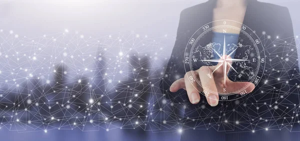 Navigasyon konsepti. Harita ve yenilik kavramı. Şehrin ışıklarının arka planında el ele tutuşan dijital ekran hologram pusula işareti. İş için pusula.