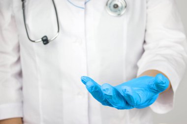 Doktor ürün ya da metin için kopyalama alanı sunuyor ve gösteriyor. Doktor tıbbi eldivenlerde boş eller veriyor. Sanal objeyi tutan profesyonel bir tıp uzmanı.