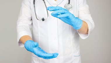 Doktor ürün ya da metin için kopyalama alanı sunuyor ve gösteriyor. Doktor boş avuç içi tıbbi eldivende..