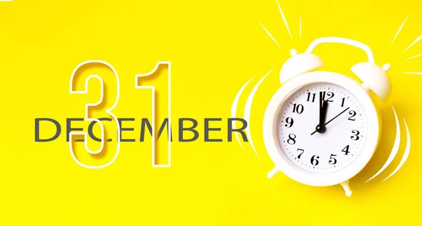 12月31日 月の31日 カレンダーの日付 黄色の背景にカレンダー日とホワイト目覚まし時計 仕事への時間 朝の最小限の概念 冬の月 その年のコンセプトの日 — ストック写真