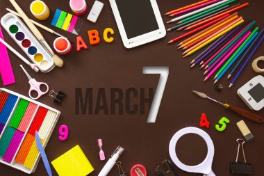 7 Mart. Ayın yedinci günü, takvim tarihi. Okul defteri ve takvim günü olan çeşitli kağıtlar. Okul ve ofis malzemeleri çerçevesi. Bahar ayı, yılın günü konsepti.