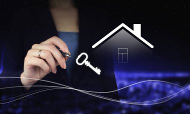 Elinde dijital grafik kalem ve şehrin karanlık arka planına dijital hologram Smart Home ve Key tabelası çiziyor. Emlakçı ev, emlak sigortası ve güvenlik teklif ediyor.