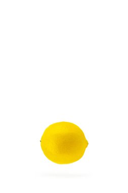 Havada uçuşan bir limon, beyaz arka planda özgürce dilimler. Uçan limon