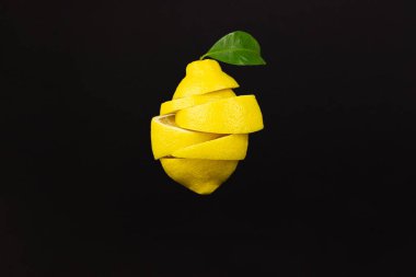 A cut lemon in levitation flies slices freely on brown background. Flying lemon