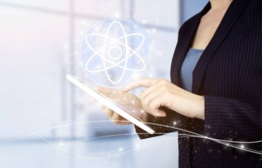 Bilim konsepti olarak atom molekülü. Işık bulanık arkaplanda dijital hologram molekül atom işareti olan beyaz tablete dokun