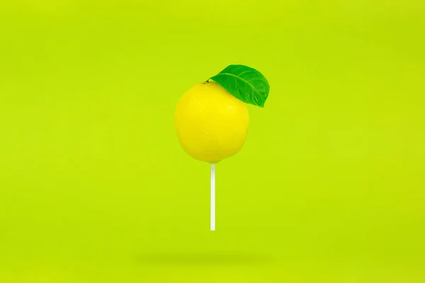 柠檬以棒棒糖的形式存在于浅绿色的背景上 单棒棒糖 — 图库照片