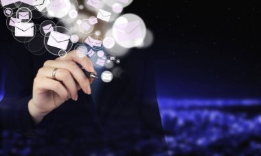 E-posta pazarlama konsepti. Haber bülteni yolluyorum. Elle tutulan dijital grafik kalem ve çizim dijital hologram E- posta ve SMS işareti şehrin karanlık arka planında bulanık