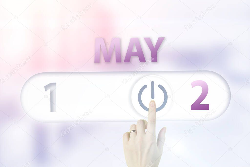 May 2nd. Day 2 of month, Calendar date.Hand finger switches pointing calendar date on sunlight office background. Spring month, day of the year concept
