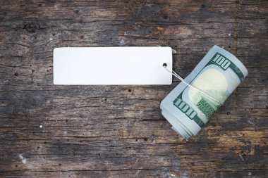 100 dolarlık banknotlar, fiyat etiketi, ekonomisi, tasarrufu ve Amerikan doları ile bir rulo haline getirildi.