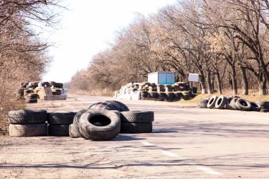 Lastikler ve beton bloklar pistte. Kontrol noktası. Yoldaki engeller. Ukrayna 'da Savaş.