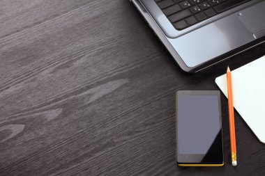 Siyah ahşap bir arka planda not defteri ve eşyalar. İşyeri.