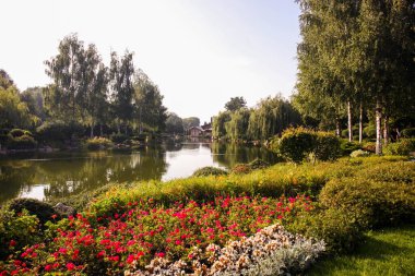 Suni gölün etrafında güzel çiçek yatakları. Mülkün peyzajı.