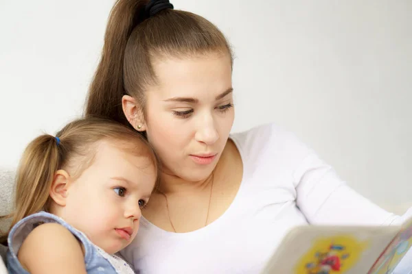 Glückliche Familie junge Mutter Babysitter halten gelesene Buch entspannen Umarmung niedliche kleine Kinder Töchter, lächelnde Eltern Mutter erzählen kleinen Kindern lustige Märchen auf dem Sofa sitzen Spaß zusammen zu Hause — Stockfoto