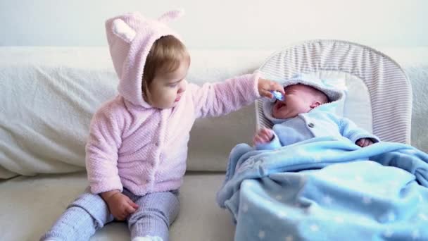 Freundschaft, Familie, Säugling, Kindheitskonzepte - zwei kleine süße lächelnde Kleinkinder entspannen beim Spielen auf einem weichen Bett. Geschwister kleine Zwillinge Bruder hat Spaß, glückliche Kinder in Quarantäne — Stockvideo