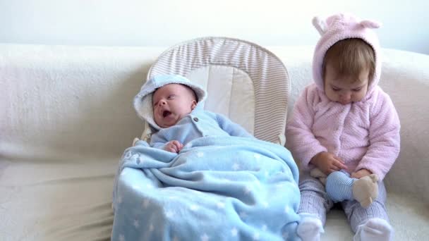 우정, 가족, 유아, 어린 시절의 개념 - 귀여운 미소를 짓는 귀여운 아기 두 명 이 부드러운 침대에서 노는 것을 편안하게 해준다. 쌍둥이 쌍둥이 동생은 격리 구역에서 재미있고 행복 한 아이들을 만난다 — 비디오
