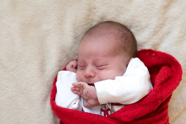 Top View Portret Eerste levensdagen Pasgeboren schattig slapende baby in pyjama 's verpakt in rode luier tapijt op witte zachte achtergrond. Vrolijk kerstfeest, Gelukkig Nieuwjaar, Baby, Jeugd, Winter kopieerruimte — Stockfoto