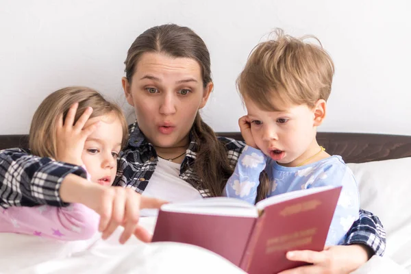 Mutlu bir aile. Sevgi dolu bir anne kızıyla birlikte yatıyor iki çocuk pijamaları yatakta ilginç hikayeler okuyor, anaokulunda gülümseyen bir kız çocuk peri masalının tadını çıkarıyor. Telifsiz Stok Imajlar