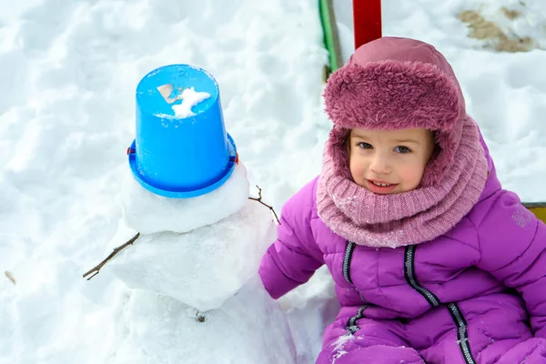 Çocuklar dışarıda karda oynuyor, kış tatilleri, oyunlar ve eğleniyorlar. Küçük Çocuklar Çocuk Oğlan ve Kız Kardeş, Sıcak giysili kardeş Şapka Eldivenler Evin arka bahçesinde kardan adam yapıyor Soğuk hava - Stok İmaj