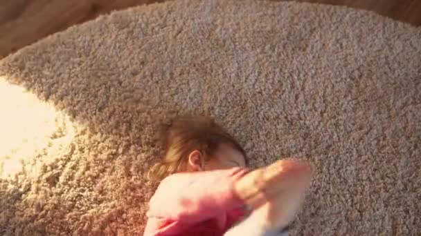 Kindheit, Liebe, Pflegekonzept. Baby Kleinkind pummelig glücklich lustig fröhlich Mädchen kriechen entspannen auf dem Boden zu Hause ruhen Nahaufnahme der nackten Beine kriecht in Richtung Spielzeug auf flauschigem Teppich drinnen im Zimmer — Stockvideo