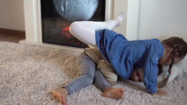 Amicizia, famiglia, giochi concetti Due sorridenti asili nido, bambini piccoli che giocano. ridere divertendosi battaglia Fratelli gemelli piccoli sul pavimento vicino al camino, bambini felici in quarantena a casa inverno — Video Stock