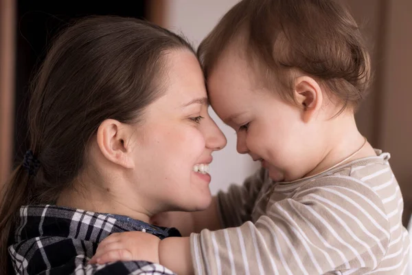 Retrato rosto adorável de pouco alegre criança bebê menina feliz com encantador sorriso olhar para a mãe forte abraços amando mamãe juntos. Mãe abraços jogar amor cuidado beijo sorrindo filha em casa — Fotografia de Stock