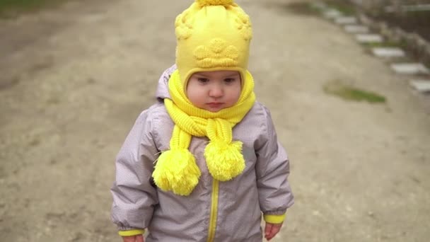 Babyrennen. Kleines Mädchen im grauen Overall mit gelbem Hut läuft durch den Waldparkweg. Kindertraum lustiges Familienkonzept. Kleinkind draußen. Spaß glückliche Kindheit sorgenfreie Kinder gehen Kind im Hof — Stockvideo