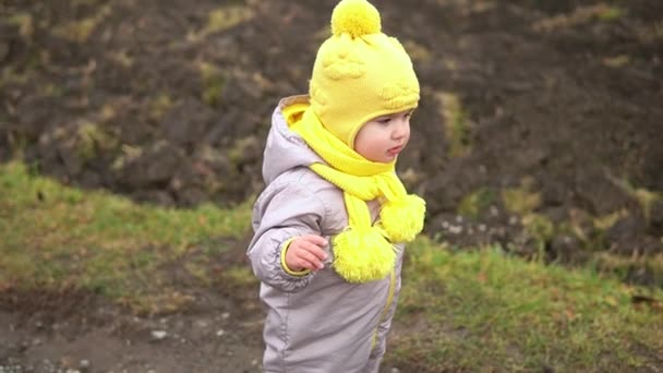 Bebé corriendo. Niña en mono gris sombrero amarillo caminando por el camino del parque forestal. niño sueño divertido concepto familiar. Un niño afuera. diversión feliz infancia despreocupado niños caminar niño en patio — Vídeo de stock