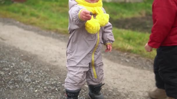 Correr do bebê.Duas crianças pequenas no chapéu amarelo cinzento do jumpsuit que anda através do trajeto do parque florestal. criança sonho engraçado conceito de família. Irmãos lá fora. diversão feliz infância despreocupado crianças menino menina andar no quintal — Vídeo de Stock