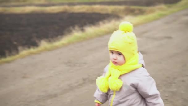 Babyrunkning. liten flicka i grå overall gul hatt promenader genom skog park väg. kid dröm rolig familj koncept. Tuddler utanför. kul lycklig barndom bekymmersfri Barn gå barn på gården — Stockvideo