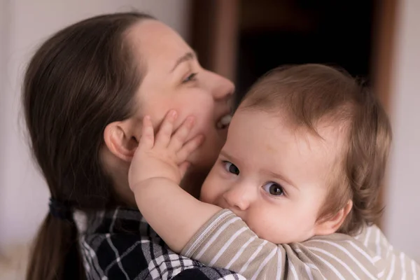 Retrato rosto adorável de pouco alegre criança bebê menina feliz com encantador sorriso olhar para a mãe forte abraços amando mamãe juntos. Mãe abraços jogar amor cuidado beijo sorrindo filha em casa — Fotografia de Stock