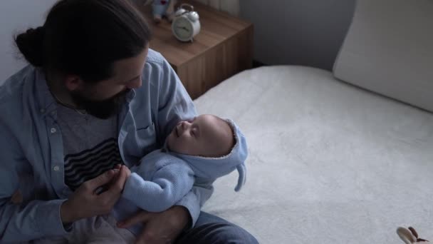 Cinematic Shot Bearded Long-haired Young Neo Father Rocking Smiling Newborn Baby In Arms At Home. Dad Holding Infant Child. Children, Parenthood, Childhood, Life, Love, Fatherhood, Family Concept — Stock Video