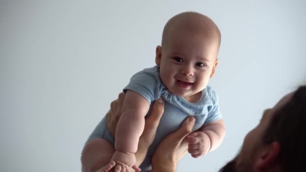 Close-up Of New Caucasian Father Sharing Tender Moment With Newborn Baby Child. Dad Have Fun Throws Infant Son Or Girl High Smiling. Kid Lifted Up With Outstretched Arms. Childhood, Parenthood Concept — 비디오