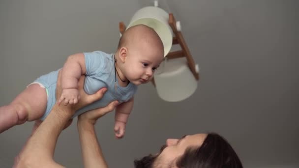Close-up Of New Caucasian Father Sharing Tender Moment With Newborn Baby Child. Dad Have Fun Throws Infant Son Or Girl High Smiling. Kid Lifted Up With Outstretched Arms. Childhood, Parenthood Concept — 图库视频影像
