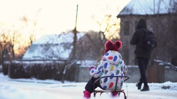 Cute Little Funny White Preschool Girl And Young Mom With Sled Ride Down Slide On Snow In Winter. Children Are Sledding. Baby Walking On Snowy Road Or Path. Childhood, Transportation, Vacation Concept — Vídeo de Stock