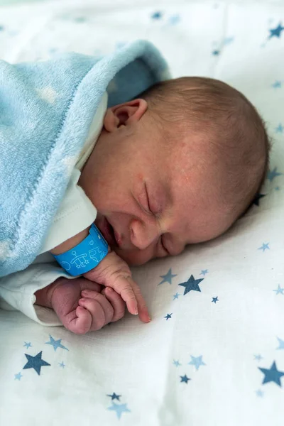 Retrato de rosto bonito vermelho do bebê recém-nascido primeiros dias dormindo na cama de vidro médico no fundo azul. Criança no início minutos de vida em Sid. Bebês, Parto, Primeiros Momentos de Borning, Princípio de Início — Fotografia de Stock
